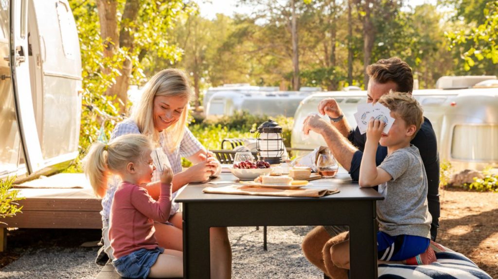 Family dining at picnic table in front of airstream at Autocamp Cape Cod