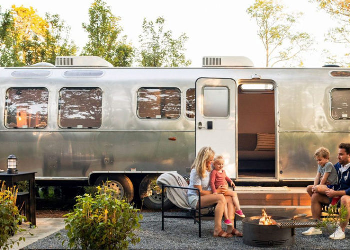 Family sitting outside in front of an airstream at Autocamp Cape Code
