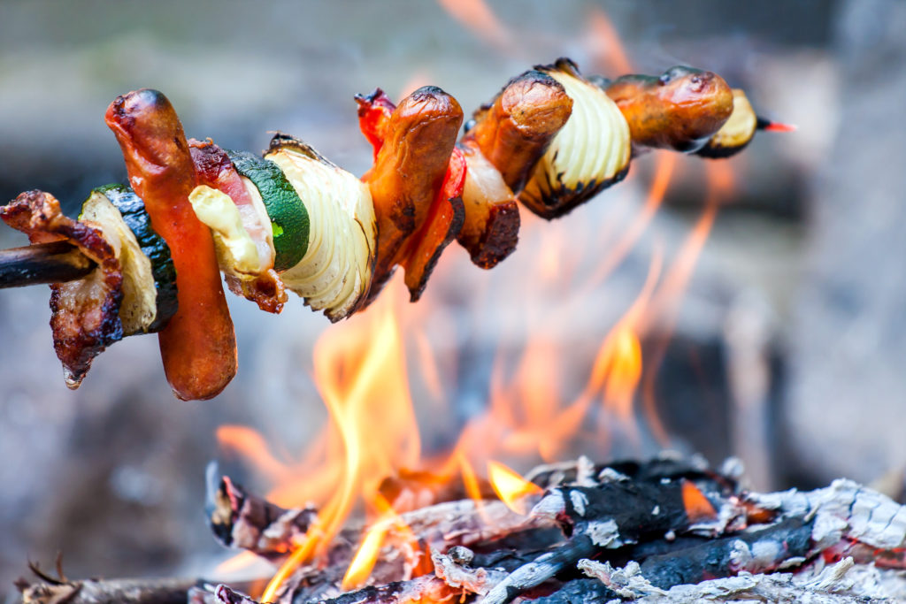 Kebab skewer with veggies and meat over an open fire