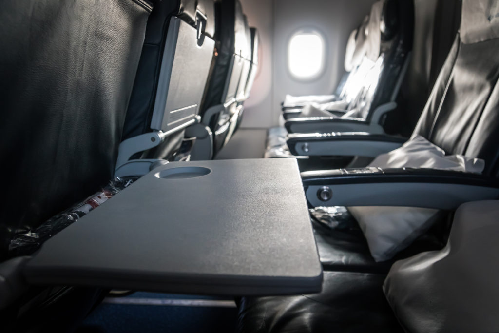 Empty airplane seats and tray tables